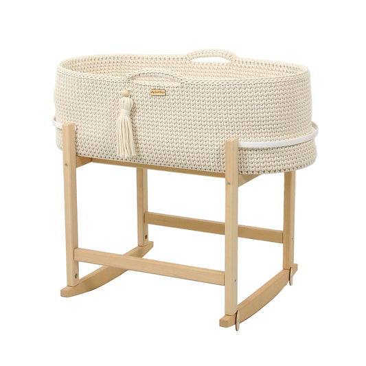 White woven baby crib with natural wood stand on a light gray background